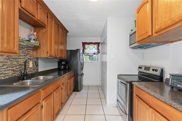 kitchen featuring backsplash, a textured ceiling, sink, electric stove, and light tile patterned floors