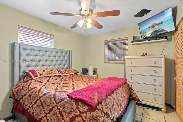 tiled bedroom featuring ceiling fan and a closet