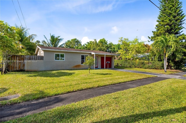 ranch-style house with a garage and a front lawn