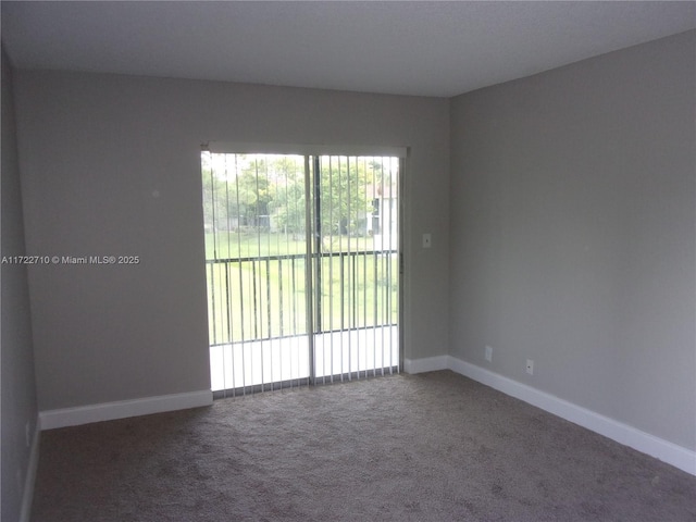 spare room with dark colored carpet