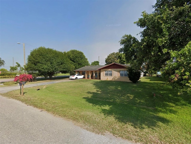 ranch-style home featuring a front lawn and driveway