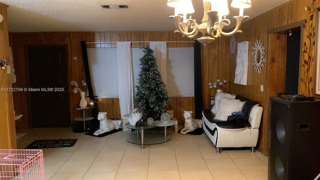 living area with wooden walls, a notable chandelier, and visible vents