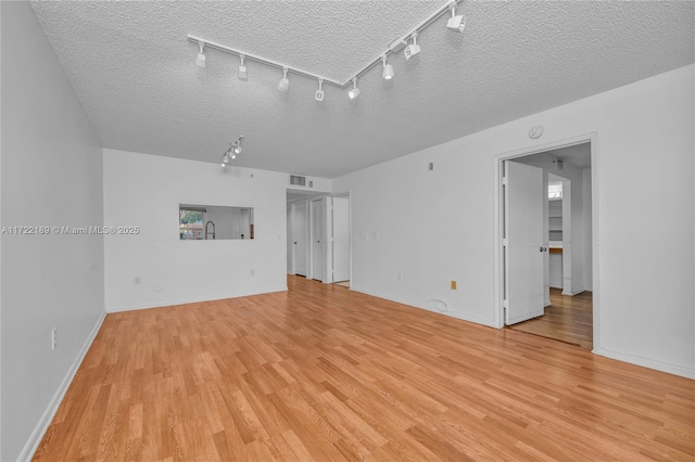 unfurnished living room featuring light hardwood / wood-style floors and a textured ceiling