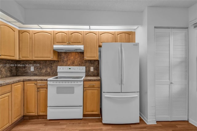 kitchen with white appliances, decorative backsplash, light brown cabinetry, and light hardwood / wood-style flooring