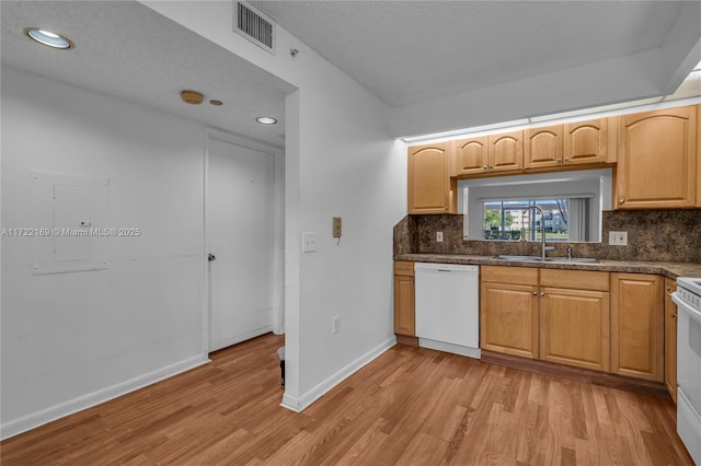 kitchen featuring white appliances, a textured ceiling, decorative backsplash, sink, and light hardwood / wood-style flooring