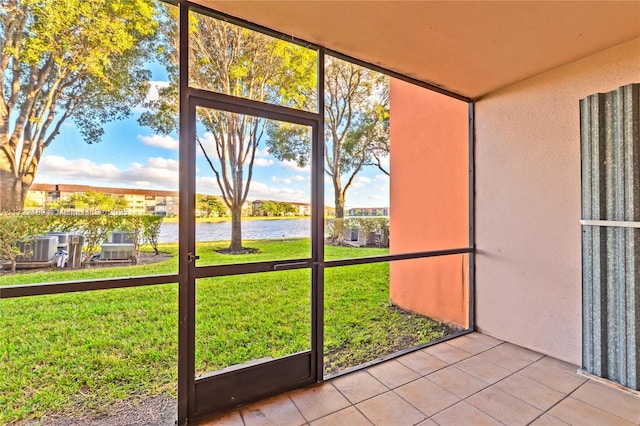 unfurnished sunroom featuring a water view