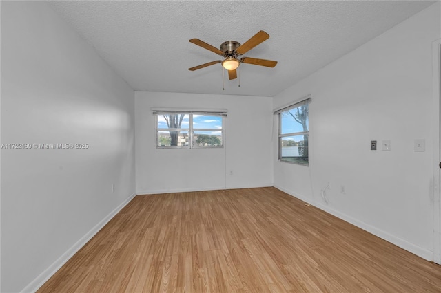 spare room featuring light wood-type flooring, ceiling fan, and a textured ceiling