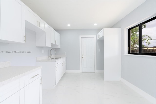 kitchen featuring white cabinets and sink