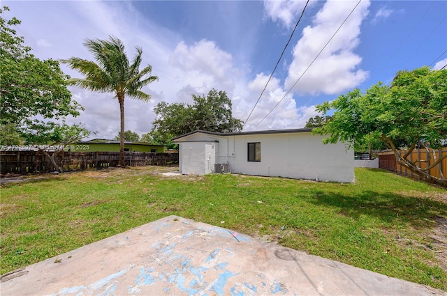 back of house with a lawn, cooling unit, and a patio