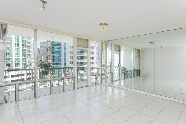 1408 Brickell Bay Dr Unit 1116, Miami, FL 33131 - tiled empty room featuring plenty of natural light, floor to ceiling windows, and a city view