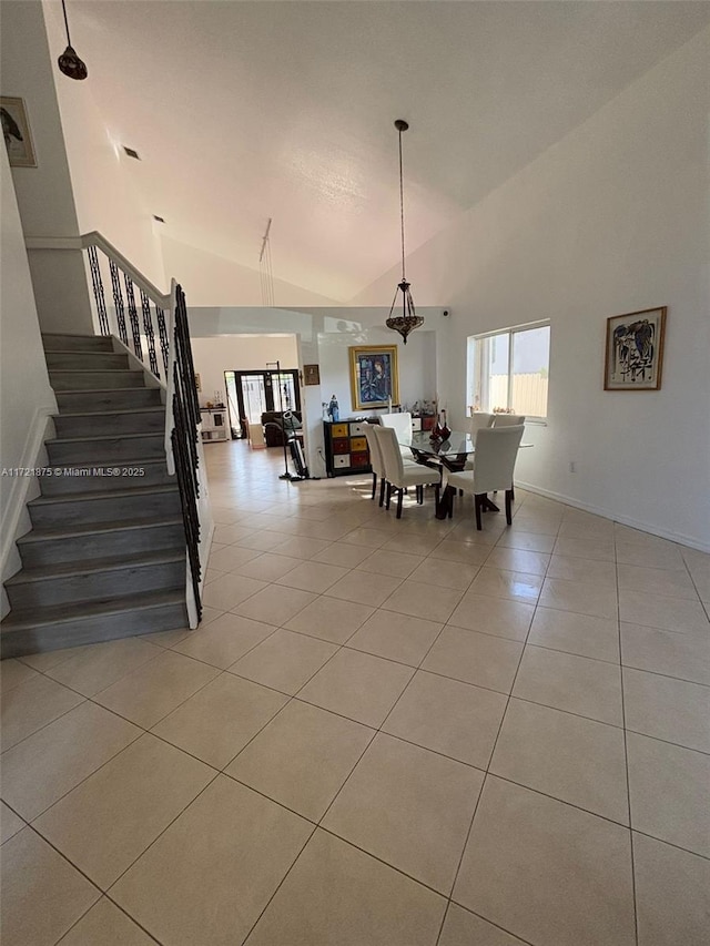 dining area with stairs, high vaulted ceiling, light tile patterned flooring, and baseboards