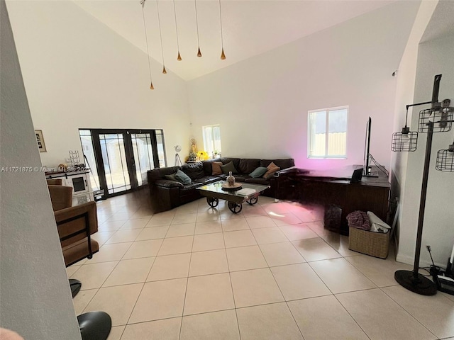 living area with high vaulted ceiling and tile patterned floors