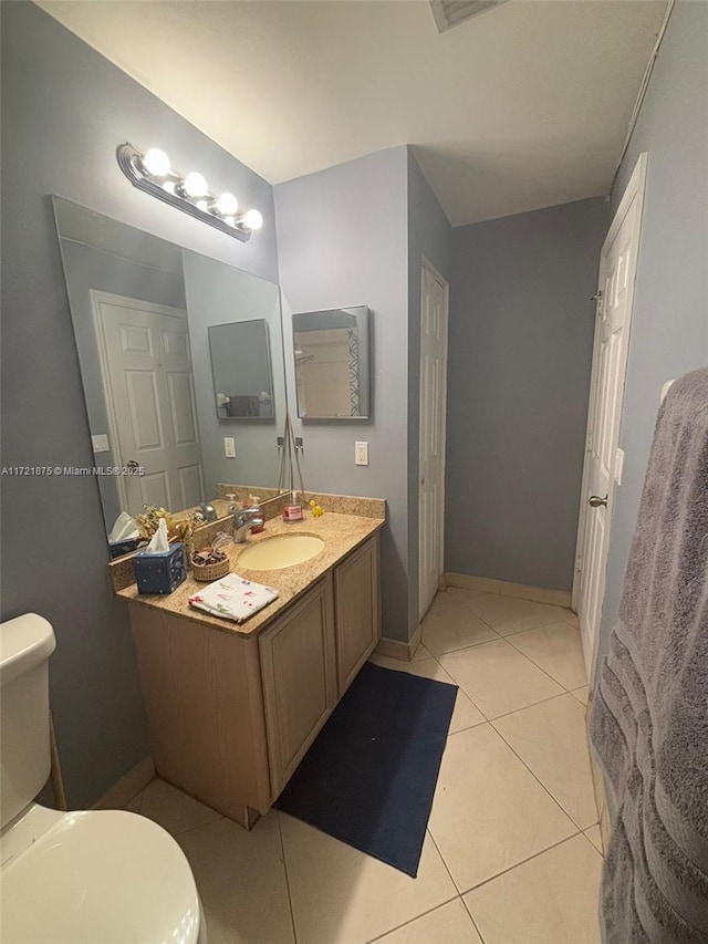 bathroom with vanity, tile patterned flooring, toilet, and baseboards