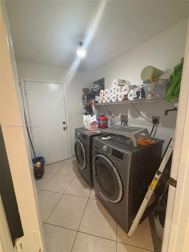 clothes washing area featuring laundry area, separate washer and dryer, and light tile patterned flooring