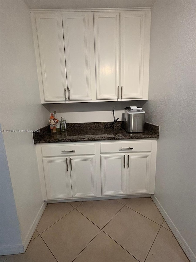 bar with light tile patterned flooring and baseboards