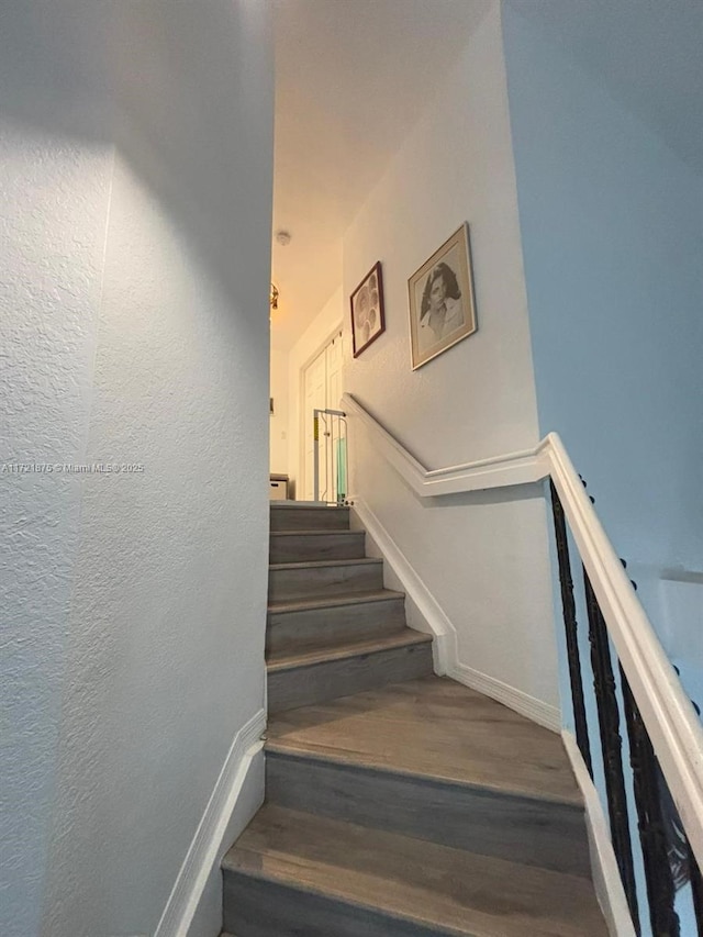 stairs with baseboards and wood finished floors