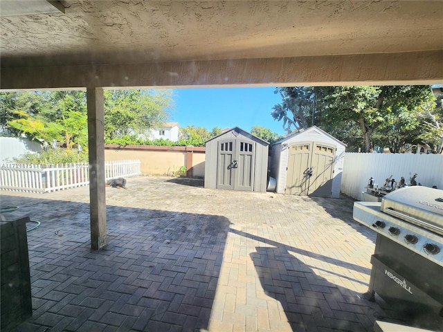 view of patio / terrace with a storage shed, a fenced backyard, and an outbuilding