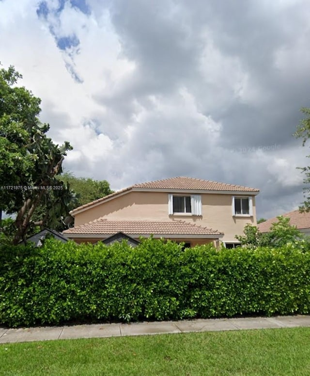 view of home's exterior featuring a tile roof and stucco siding