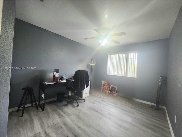 office featuring wood finished floors, a ceiling fan, and baseboards