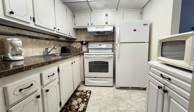 kitchen featuring white appliances, backsplash, white cabinets, sink, and light tile patterned floors