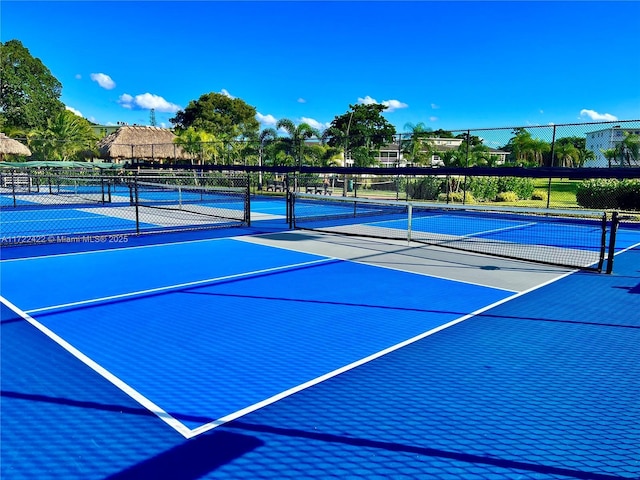 view of tennis court featuring basketball hoop