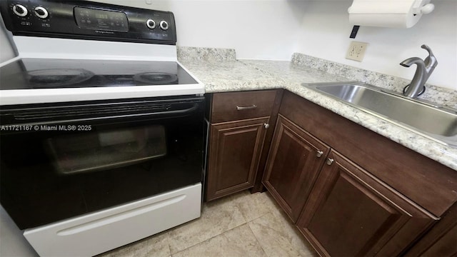 kitchen featuring sink, light tile patterned floors, dark brown cabinets, and white electric stove