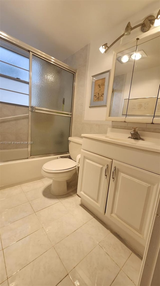 full bathroom with tile patterned flooring, vanity, toilet, and enclosed tub / shower combo