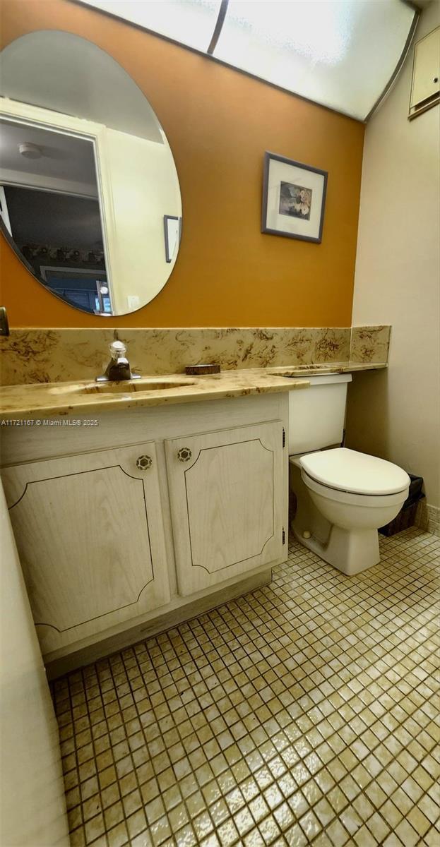 bathroom with tile patterned flooring, vanity, and toilet