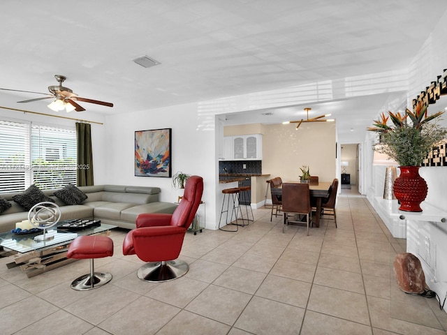 living room with light tile patterned floors and ceiling fan with notable chandelier