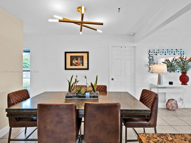 dining space featuring light tile patterned floors and an inviting chandelier