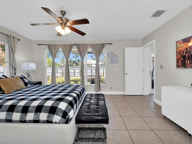 tiled bedroom featuring multiple windows and ceiling fan