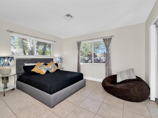 bedroom with light tile patterned floors and multiple windows