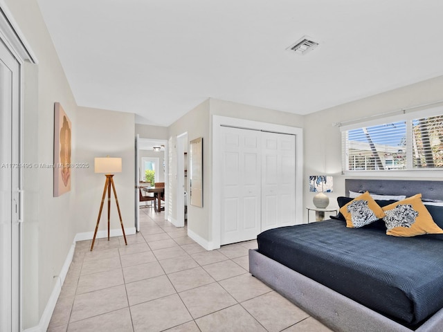 bedroom featuring multiple windows, a closet, and light tile patterned flooring