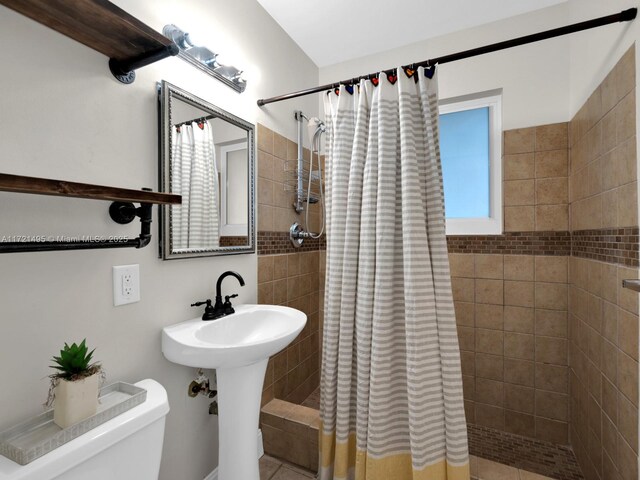 bathroom featuring sink, toilet, and a shower with shower curtain