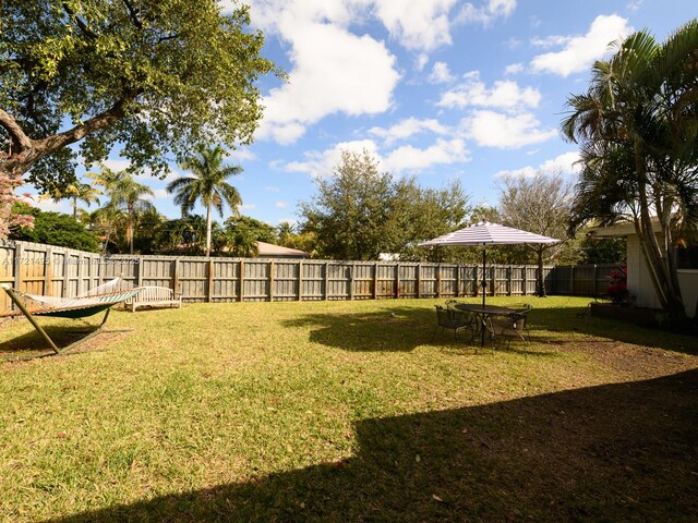 rear view of property with a yard and a storage unit