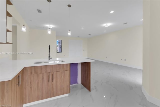 kitchen with kitchen peninsula, sink, and hanging light fixtures