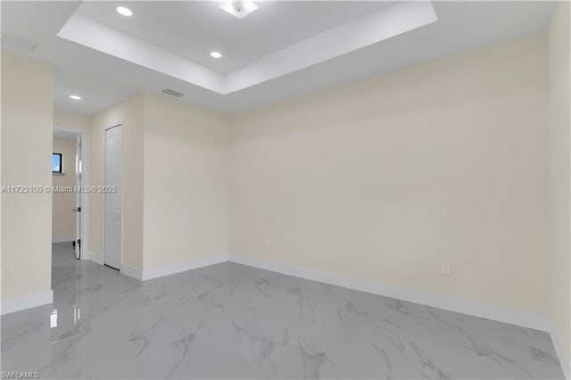 unfurnished room with a tray ceiling