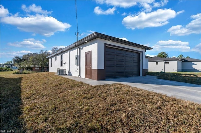 view of property exterior with a yard, a garage, and central AC unit