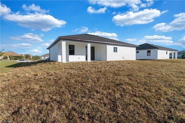 rear view of property with a lawn