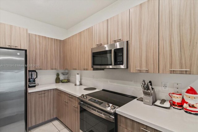 kitchen featuring tile patterned flooring, stainless steel appliances, and sink