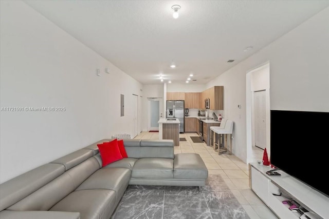 living room with light tile patterned flooring, electric panel, and a textured ceiling