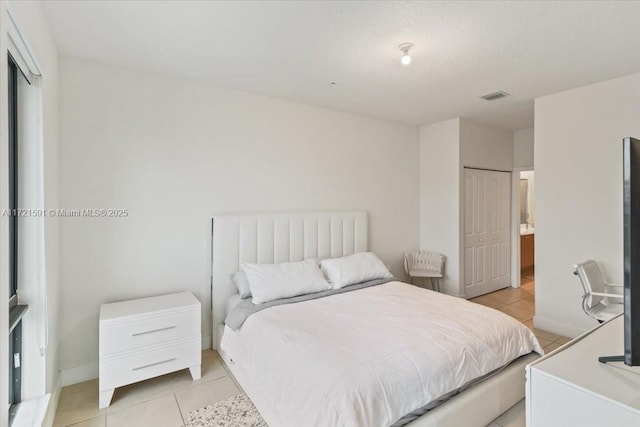 tiled bedroom with a closet