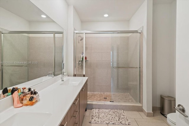 bathroom featuring vanity, a shower with shower door, tile patterned floors, and toilet