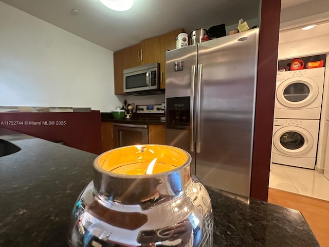 kitchen with stainless steel appliances and stacked washer / dryer