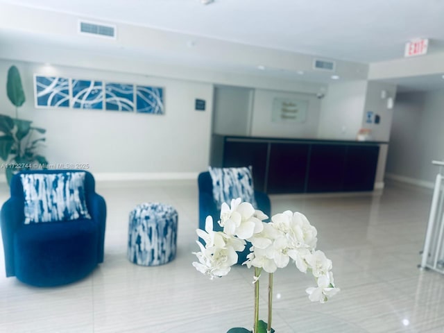 tiled living room featuring visible vents and baseboards