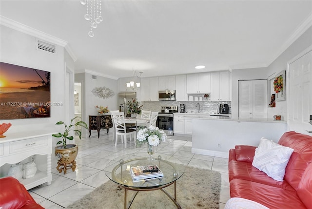 tiled living room featuring a notable chandelier, crown molding, and sink