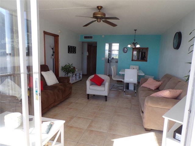 living room with light tile patterned floors and ceiling fan with notable chandelier