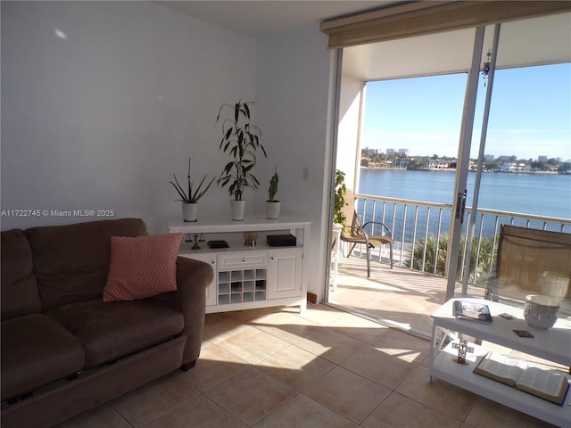 living room featuring light tile patterned floors and a water view