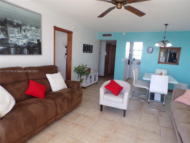 tiled living room featuring ceiling fan with notable chandelier