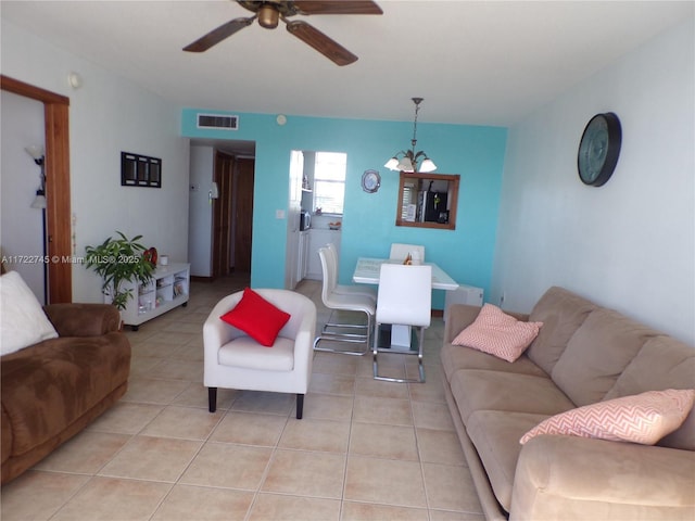 living room with ceiling fan with notable chandelier